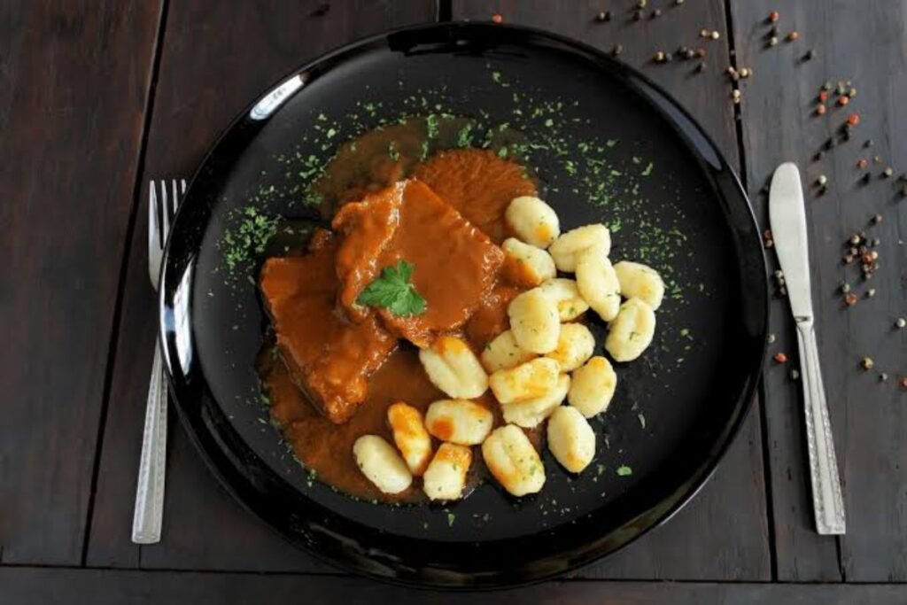 Traditional Croatian food spread featuring grilled meats, fresh seafood, rustic breads, local cheeses, and colorful Mediterranean-inspired dishes on a beautifully styled dining table.